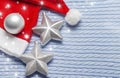 Two Christmas stars with a red Santa hat on a blue knitted fabric background with snowflakes Royalty Free Stock Photo