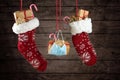 Two Christmas stockings and a protective face mask against covid-19 infection filled with gifts and sweets hanging in front of a Royalty Free Stock Photo