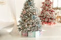 Two Christmas trees with lights glowing garlands and gifts. Cozy living room interior with decorated Christmas tree. Royalty Free Stock Photo