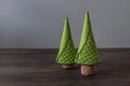 Two Christmas trees made of waffle cones and champagne corks on a wooden table.