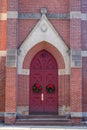 Red church doors with Christmas wreaths Royalty Free Stock Photo