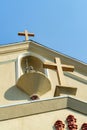 Two church crosses on outside building or steeple in sun midday with orange stucco and white accent colors in city Royalty Free Stock Photo