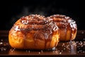 two cinnamon buns with caramel on a wooden table