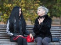 Two city girls talking on a park bench Royalty Free Stock Photo