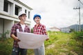 Two Civil Engineers, field engineers, foreman, owner standing in the construction site project in the background Royalty Free Stock Photo