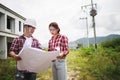 Two Civil Engineers, field engineers, foreman, owner standing in the construction site project in the background Royalty Free Stock Photo
