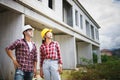 Two Civil Engineers, field engineers, foreman, owner standing in the construction site project in the background Royalty Free Stock Photo