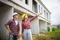 Two Civil Engineers, field engineers, foreman, owner standing in the construction site project in the background Royalty Free Stock Photo