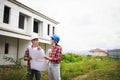 Two Civil Engineers, field engineers, foreman, owner standing in the construction site project in the background Royalty Free Stock Photo