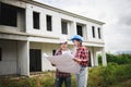 Two Civil Engineers, field engineers, foreman, owner standing in the construction site project in the background Royalty Free Stock Photo