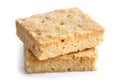 Two classic homemade square shortbread biscuits stacked and isolated on white.