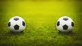 Two classic soccer balls, one in front another, placed on the green grass stadium turf. Traditional football playing ball on Royalty Free Stock Photo