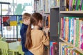 Two classmates choose books in library. Concept of studying, back to school, friends and education Royalty Free Stock Photo