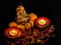 Two clay lamp glowing on flower petals with buddha statue over the background. faith and belief concept