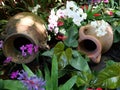 Two clay pots in a garden surrounded by colorful flowers Royalty Free Stock Photo