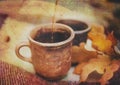 Two Clay Rural Cups with Hot Beverage are on the Wool Plaid with Autumnal Leaves.Nature Background.Selective Focus