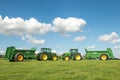 Two green John Deere tractors pulling bunning muck spreaders