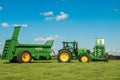 Two green John Deere tractors pulling bunning muck spreaders