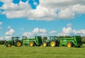 Two green John Deere tractors pulling bunning muck spreaders