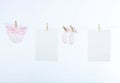 Two clean sheet of paper and babyÃâs clothes Royalty Free Stock Photo