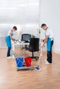 Cleaners With Cleaning Equipments Cleaning The Office Royalty Free Stock Photo