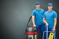 Two Cleaners Standing On Gray Background Royalty Free Stock Photo