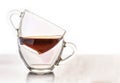 Two clear glass cups that stand side by side. One empty, the second pour tea. Isolated on a white background Royalty Free Stock Photo