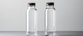 Two clear plastic bottles with black lids on a table Royalty Free Stock Photo