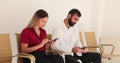 Two clients using a smartphone in waiting center