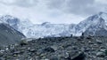 Two climbers with large backpacks are walking on the rocks. Climbing Mount Belukha. Beautiful mountain winter landscape