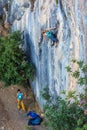 Two Climbers work in pair on vertical rocky Wall