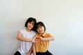 Two close girls show their love by raising their hands in a heart shape. instead displayed on a plaster background. Royalty Free Stock Photo