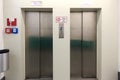 Two closed metal elevator doors in underground parking