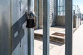 Two closed padlocks on the metal entrance door to a power station.. A metal lock in close-up on the grate.