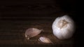 Two cloves of garlic and one garlic on a wooden table Royalty Free Stock Photo