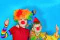 Two clowns cuddle and put their thumbs up Royalty Free Stock Photo