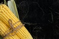 Two cobs of corn on a black wooden table Royalty Free Stock Photo