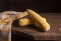 Two cobs sweet corn on wooden background