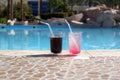 Two cocktail glasses near swimming pool blue water Royalty Free Stock Photo