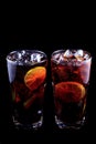Two cocktail Long Island Iced Tea on a black background. Royalty Free Stock Photo