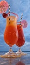 two cocktails are displayed in front of the ocean, one has an umbrella and Royalty Free Stock Photo