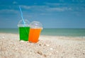 Two cocktails drink sand close-up against the background of the sea and sky, clouds a glass a tube for drinking liquid, soda