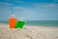 Two cocktails drink sand close-up against the background of the sea and sky, clouds a glass a tube for drinking liquid, soda