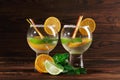 Two cocktails with rum and fruits. Appetizer fruits and spicy mint for a cold drink. Cocktails on the wooden background. Royalty Free Stock Photo