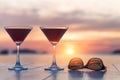 Two cocktails and sunglasses at a beach restaurant, honeymoon, sunset Royalty Free Stock Photo