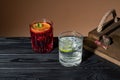 Two coctails on a wooden table near a tray, one Negroni other Caipirinha, traditional Brazilian alcoholic drink, typical Royalty Free Stock Photo