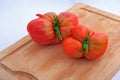 Two coeur du boeuf tomatoes on wooden cutting board Royalty Free Stock Photo