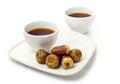 Two coffee cups and dates.