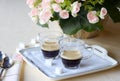 Two coffee cups of espresso coffee on the table on a porcelain