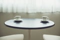 Two coffee cups on table near windows morning